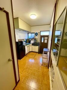 a kitchen with a chair in the middle of a room at 古民家宿誠makoto in Tamano