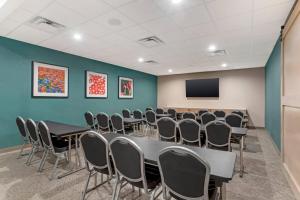 a conference room with tables and chairs and a tv at Cambria Hotel Euless - DFW Airport South in Euless