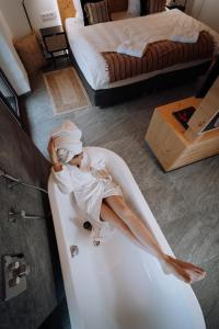 a woman sitting in a bath tub in a bedroom at Winzerhof - Deutsch Haseldorf in Deutsch Haseldorf