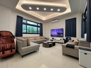 a living room with couches and a flat screen tv at 荷民宿 HO Homestay in Yuanshan