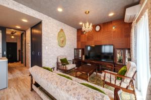 a living room with a couch and a television at ルグランみしま Private lodging in Hamamatsu