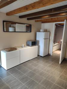 a kitchen with white cabinets and a refrigerator at l'Echappée Crançotine in Crançot