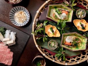 a table with plates of food on a table at Sui Suwako in Suwa