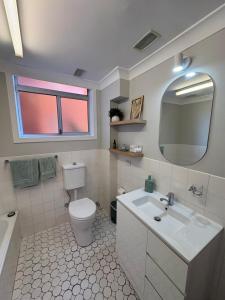a bathroom with a toilet and a sink and a mirror at Melrose Place at Flynn's Beach in Port Macquarie +47 photos