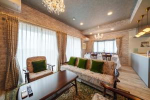 a living room with a couch and chairs and a table at ルグランみしま Private lodging in Hamamatsu