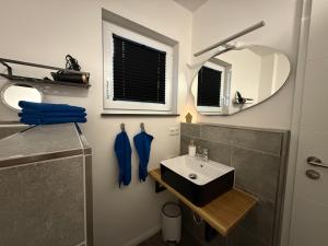 a bathroom with a sink and a mirror at Inselbutze Fehmarn in Fehmarn +26 photos
