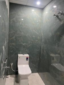 a bathroom with a toilet and a stone wall at HOMESTAY KT palace in Varanasi +18 photos