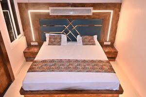 a bedroom with a bed with a wooden headboard at HOMESTAY KT palace in Varanasi