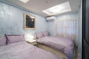 two beds in a small room with purple sheets at ルグランみしま Private lodging in Hamamatsu +286 photos