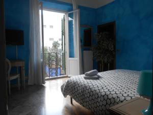 ein blaues Schlafzimmer mit einem Bett und einer offenen Tür in der Unterkunft Scala Apartment in Florenz