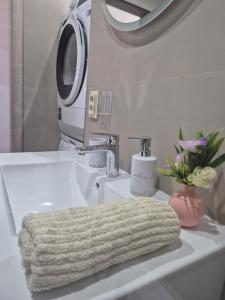 a bathroom with a sink with a towel on it at Apartmán LUX Lučenec in Lučenec