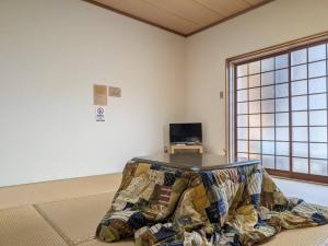 a room with a table in the middle of a room at Amanohashidate Youth Hostel in Miyazu