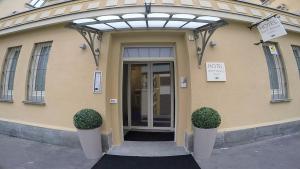 una porta d'ingresso di un edificio con due piante davanti di Hotel Sant'Anna a Torino