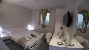 um quarto de hotel com uma cama e duas mesas e uma televisão em Hotel Sant'Anna em Turim