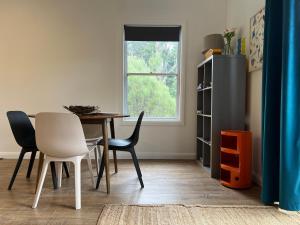 a dining room with a table and chairs and a window at Happy Mountain House in Blackheath