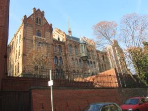 a large brick building with cars parked in front of it at Judy and Sandor Apartmen in Budapest