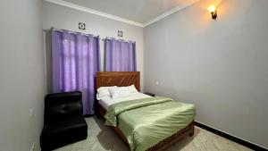 Un dormitorio con una cama y una ventana con cortinas moradas. en Yoyo Celestial Home, en Arusha