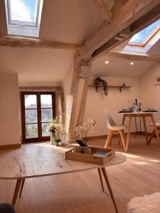 a living room with a table and a dining room at Le Blanc Spa in Nanteuil-en-Vallée