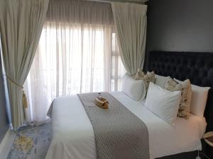 a bedroom with a large white bed with a large window at URlyfstyle Kikuyu Escape Waterfall Mall of Africa in Midrand +60 photos