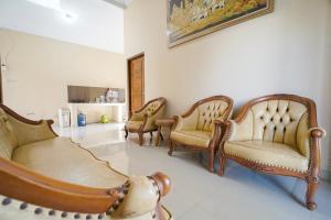 a living room with three chairs and a couch at Villa Maurine Prambanan in Jogonalan