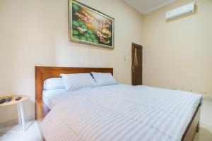 a bedroom with a bed and a picture on the wall at Villa Maurine Prambanan in Jogonalan +32 photos