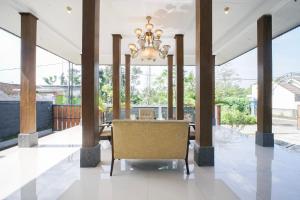 a dining room with a table and a chandelier at Villa Maurine Prambanan in Jogonalan
