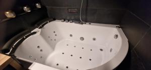 a white bath tub in a bathroom with a counter at love room, sauna et balnéo in Perros-Guirec