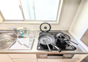 a kitchen with a stove with a frying pan on it at Chateau Sunrise in Tokyo +105 photos