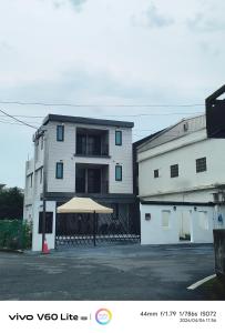 a white building with a tan umbrella in front of it at Fu Qiaoqing Travel電梯獨棟 in Wujie