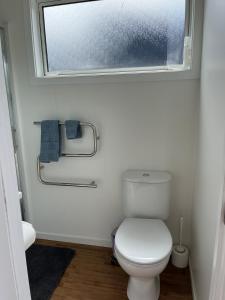 a bathroom with a white toilet and a window at The Bothy by the lake in Lake Hāwea