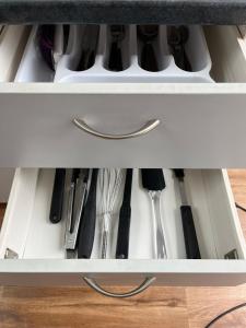 a drawer filled with knives and other kitchen utensils at The Bothy by the lake in Lake Hāwea