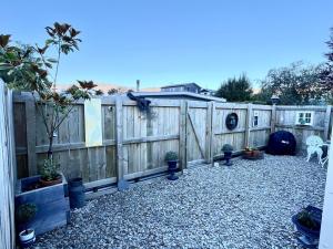 a fence with potted plants in a backyard at The Bothy by the lake in Lake Hāwea