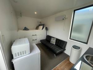 a small room with a couch and a bed at The Bothy by the lake in Lake Hāwea +9 photos