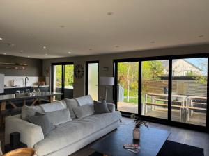 a living room with a white couch and a kitchen at Uno Moor Side - 4 Bed, 2 Bath, Garden, sleeps 8 - Parking in Carbis Bay