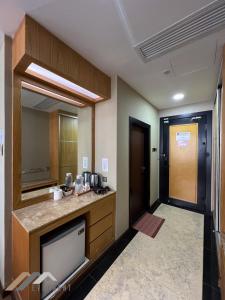 a room with a kitchen with a sink and a mirror at Evernent Meritz in Miri