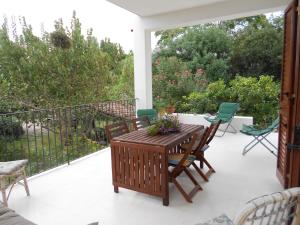 patio con mesa y sillas en el balcón en Casa del Gelso Mortelle, en Torre Faro