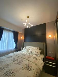a bedroom with a bed and a chandelier at Podomoro Golf View By Ohara Property in Tjikuda Tiga
