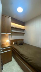 a bedroom with a bed and a desk with a lamp at Podomoro Golf View By Ohara Property in Tjikuda Tiga