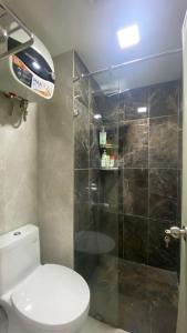 a bathroom with a toilet and a glass shower at Podomoro Golf View By Ohara Property in Tjikuda Tiga