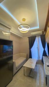a living room with a couch and a table at Podomoro Golf View By Ohara Property in Tjikuda Tiga