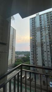 a balcony with a view of some tall buildings at Podomoro Golf View By Ohara Property in Tjikuda Tiga