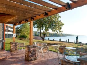 een patio met tafels en stoelen en uitzicht op het water bij East Bay Suites in Grand Marais