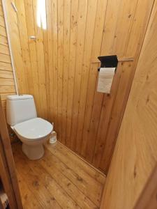 a bathroom with a toilet in a wooden wall at Gästezimmer Arcoiris in Seifhennersdorf