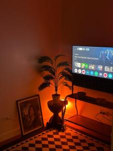 a computer monitor and a plant in a room at Haus by Juju in Manila