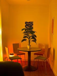 a table with a plant in a room with chairs at Haus by Juju in Manila