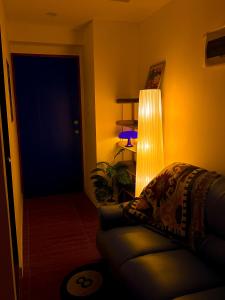 a living room with a couch and a lamp at Haus by Juju in Manila