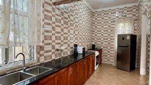 una cocina con fregadero y refrigerador en Yoyo Celestial Home, en Arusha 16 fotos más
