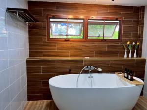 eine Badewanne in einem Badezimmer mit Holzwänden in der Unterkunft Doungploy BaanruenThai Homestay in Ban Hua Phrong + 60 Fotos