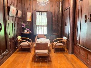 ein Zimmer mit Tisch und Stühlen und einem Fenster in der Unterkunft Doungploy BaanruenThai Homestay in Ban Hua Phrong