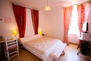 a bedroom with a white bed and red curtains at Logis Auberge La Cremaillere in Villandraut